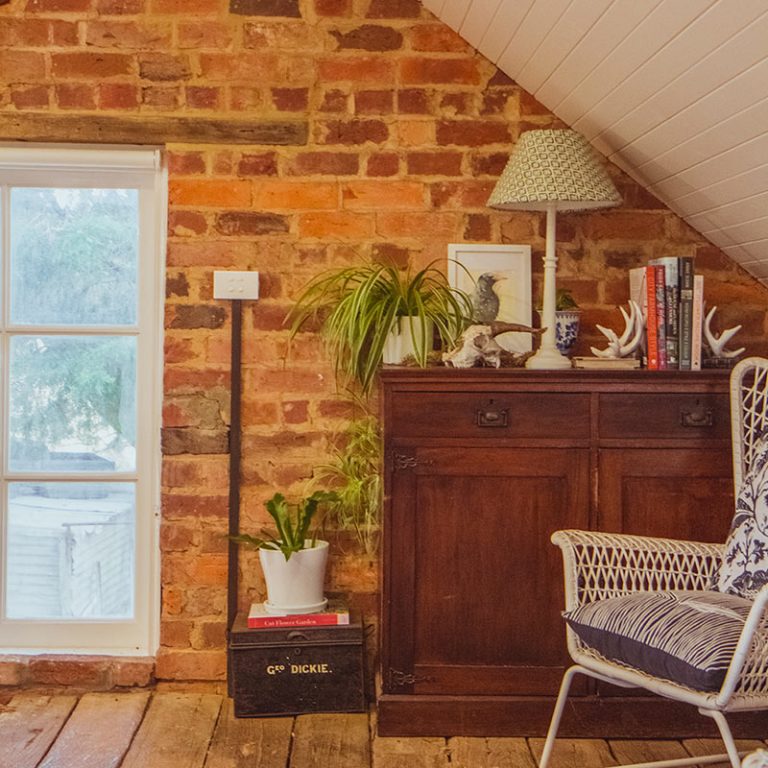 An exposed brick wall in a bedroom