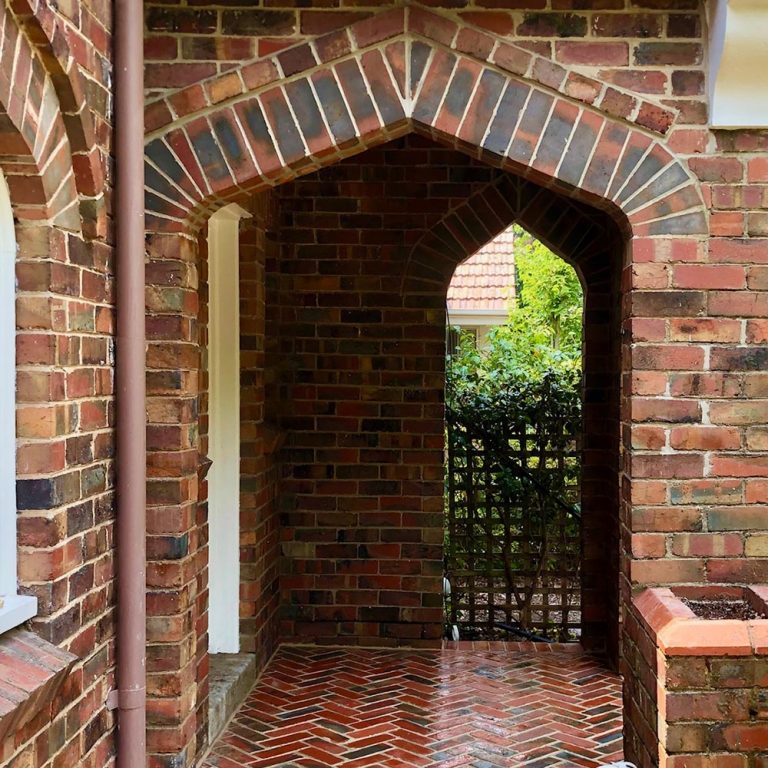 A heritage style outdoor brick archway with triangular detailing